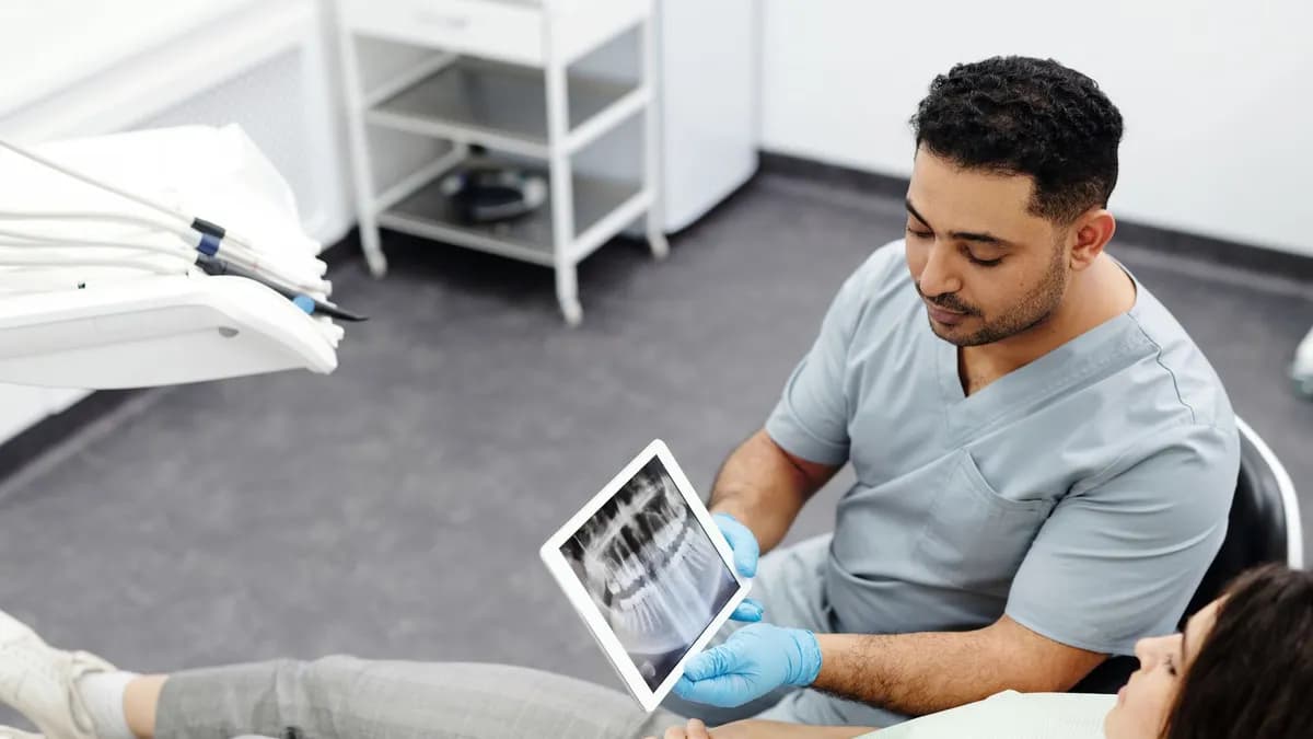 Dentist showing a patient a treatment plan on a tablet